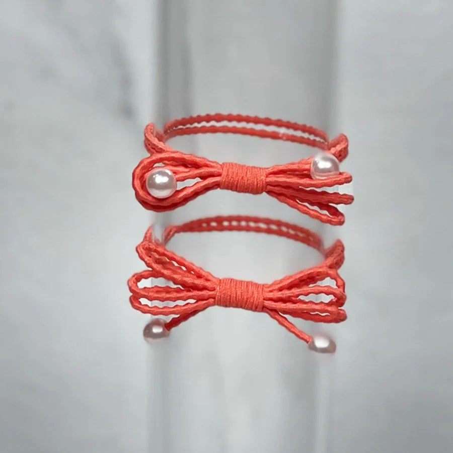 Coral bow hair ties for women with pearl accents and textured elastic bands