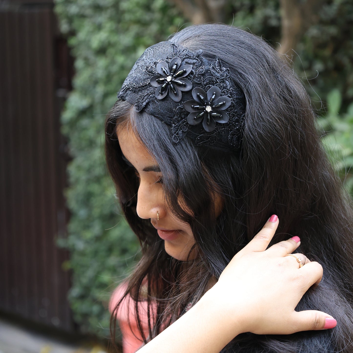 Black broad flower hairbands with lace and floral embellishments worn by woman with long dark hair