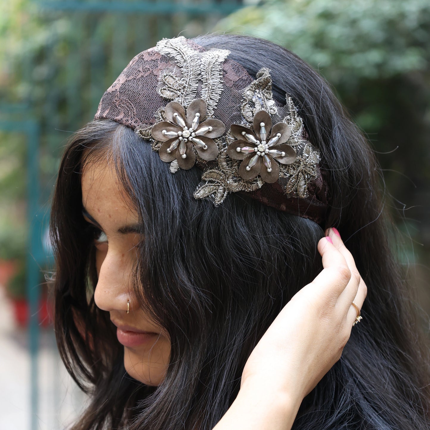Brown lace broad flower hairbands with pearl accents worn by woman with long black hair