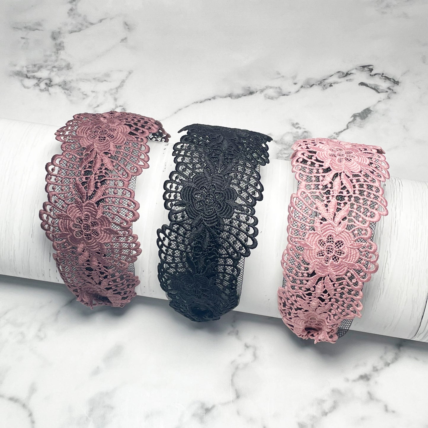 Set of three broad lace hairbands in pink, black, and dusty rose with floral patterns
