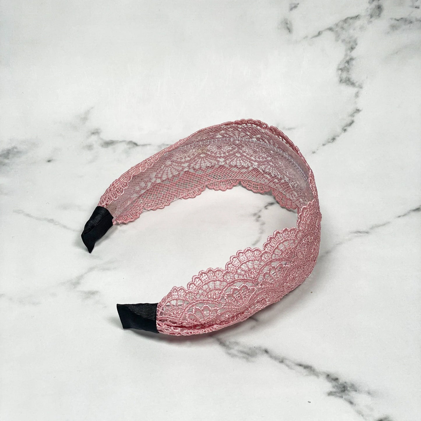Pink broad lacy hairband with intricate floral lace design and black inner tips
