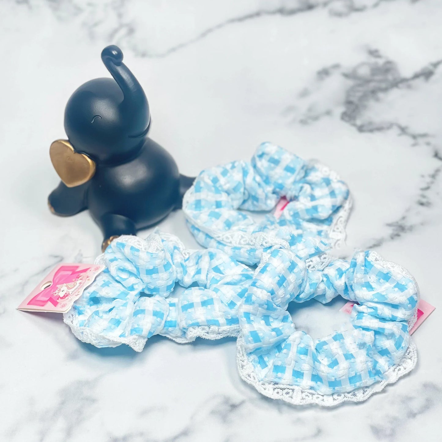 Blue and white check scrunchies with lace trimming on a marble surface from mydevelopmentstor