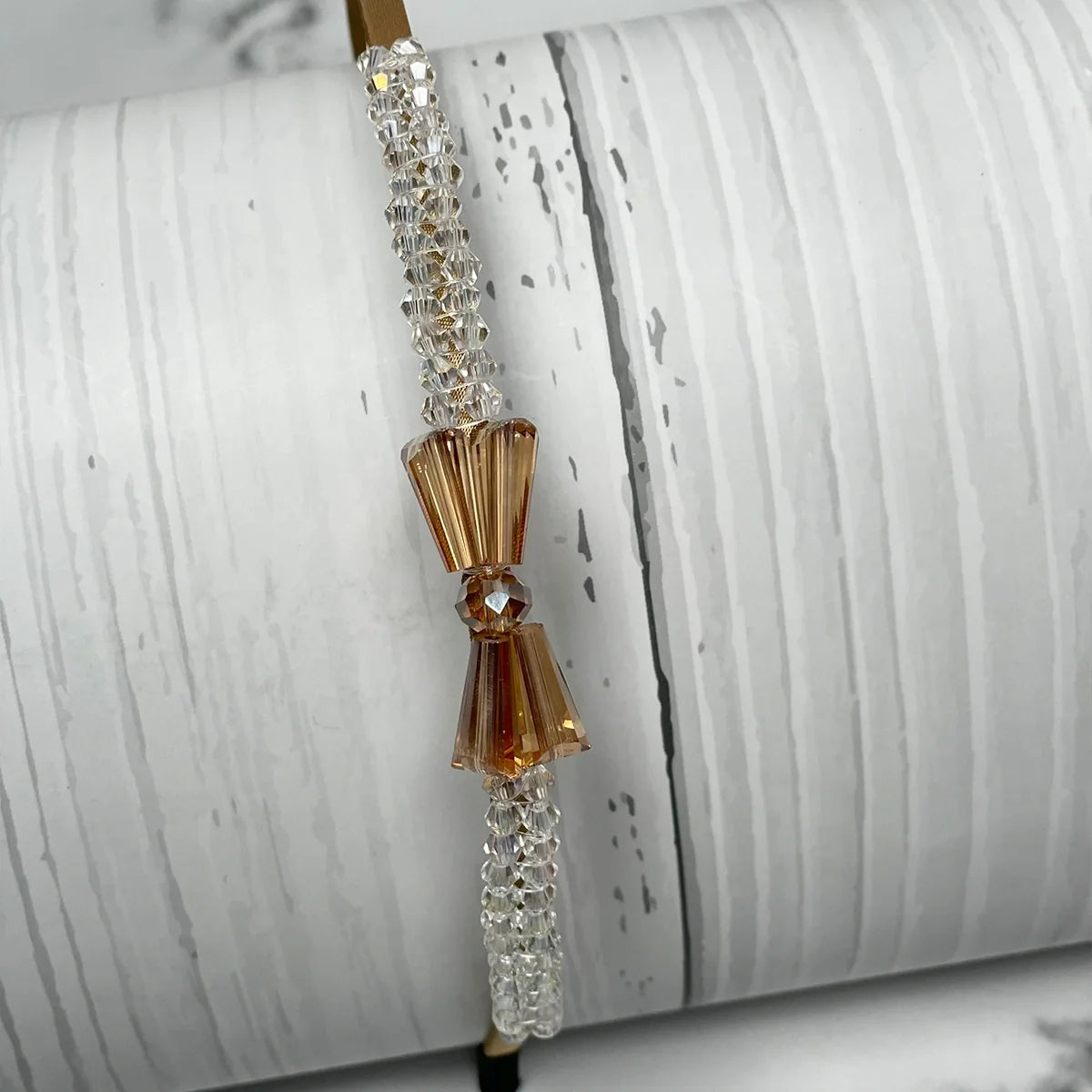 Elegant crystal bow hairbands featuring clear and amber crystal beads on a sleek band