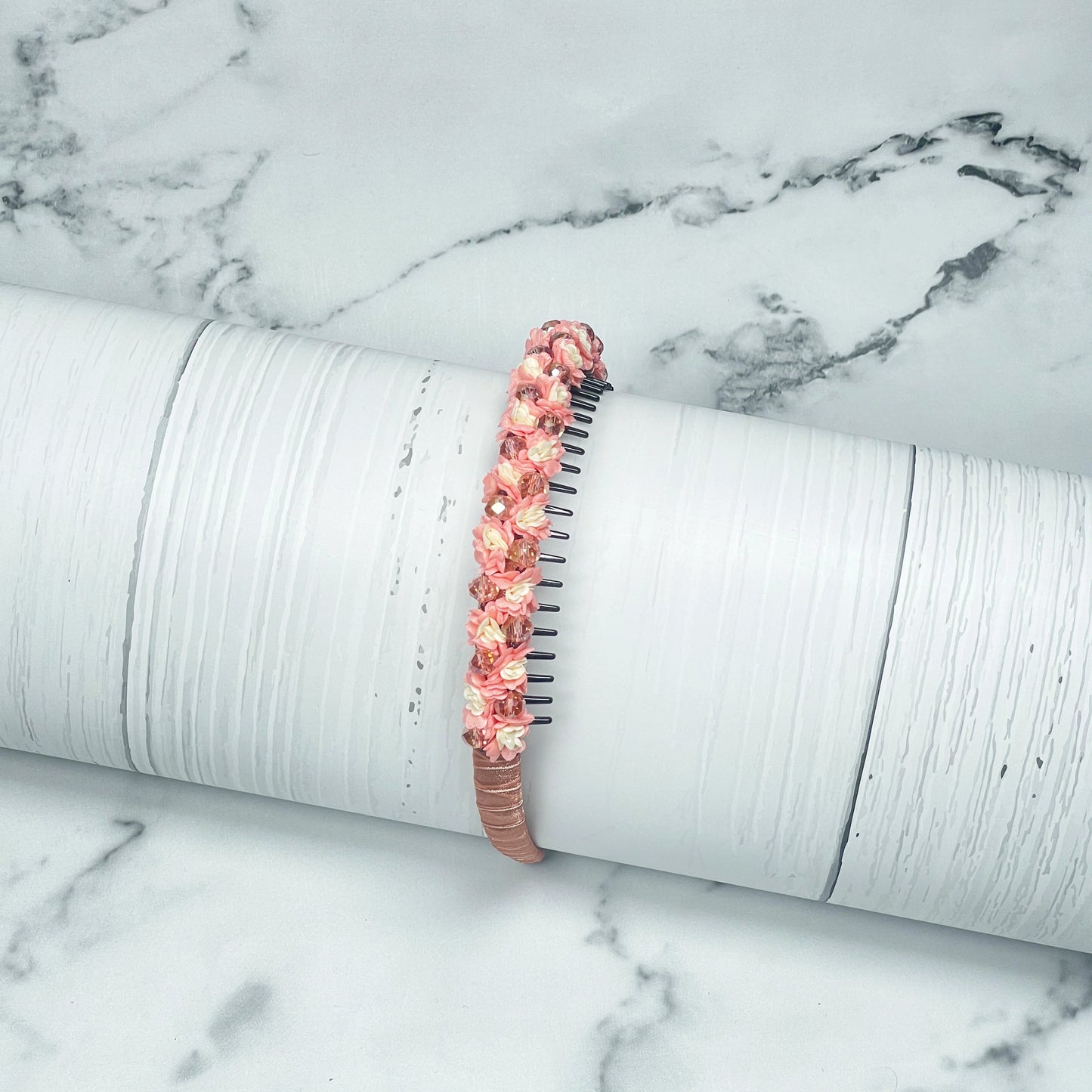 Pink crystal flower studded hairbands with intricate floral design on a white marble background