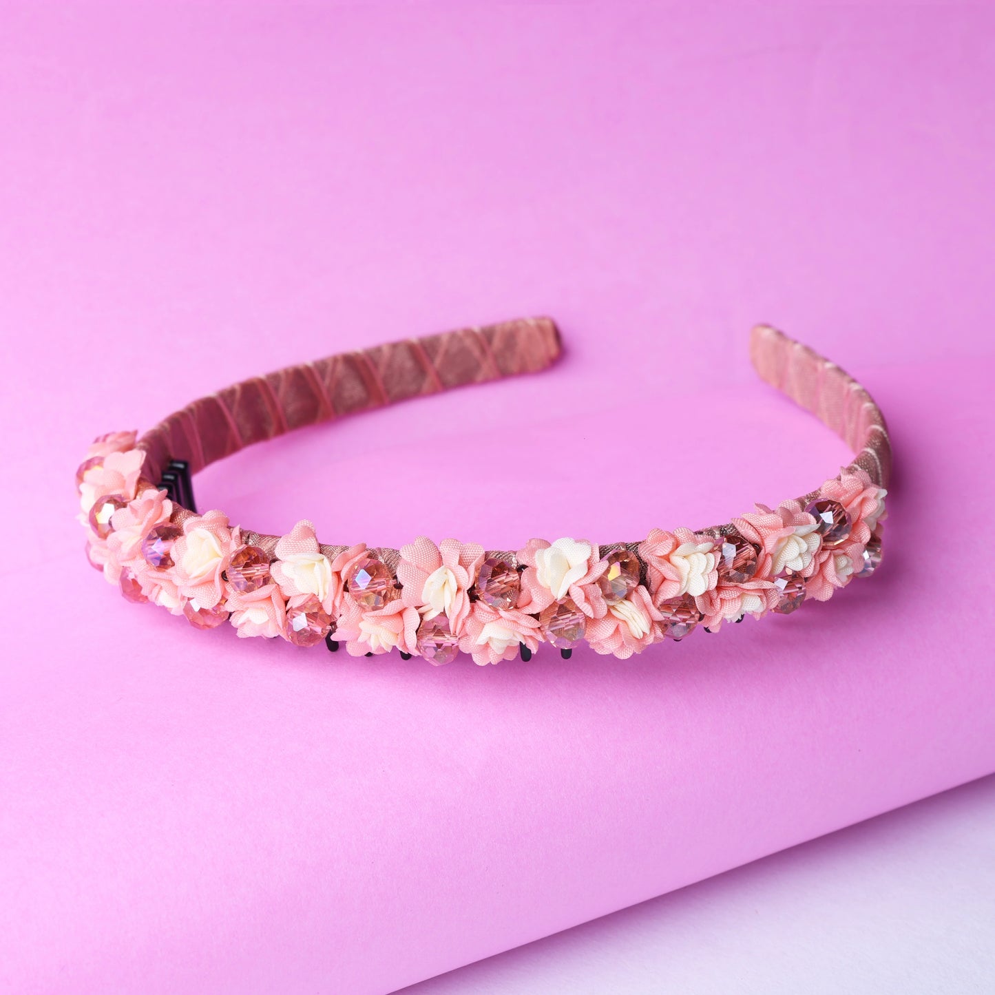 Pink crystal flower studded hairbands with delicate floral design on a soft pink background