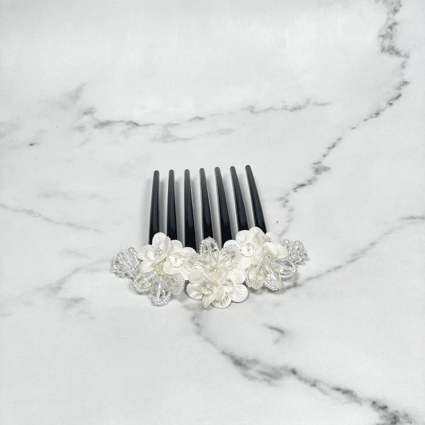 Black hair comb with white floral decorations and crystal studded comb clips for elegant hairstyles