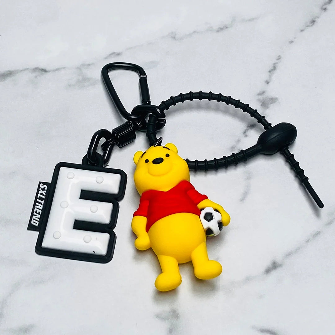 Disney bag tag featuring Winnie the Pooh holding a soccer ball with black letter E charm