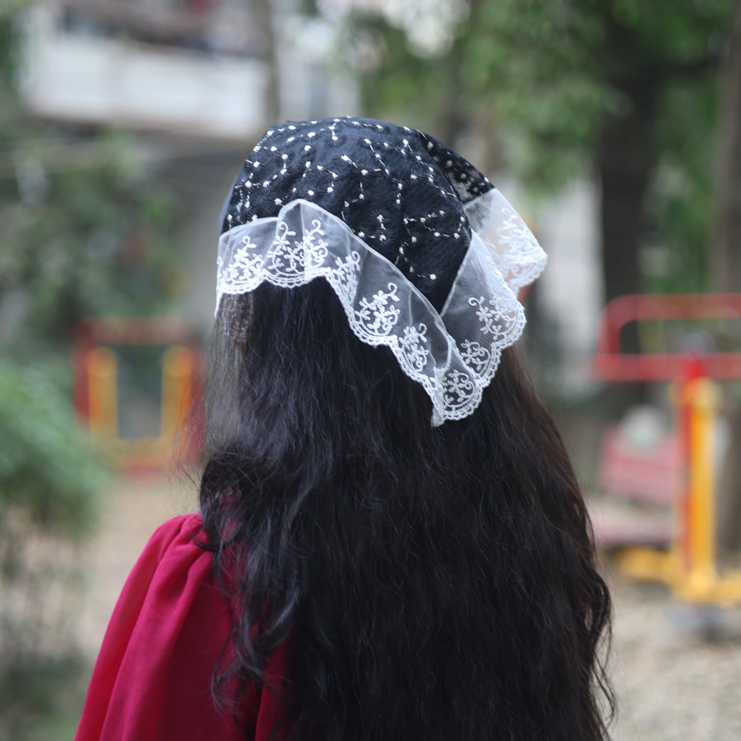 Black and white Bella Luxe Embroidered Shimmery Lacy Bandana worn over long dark hair outdoors