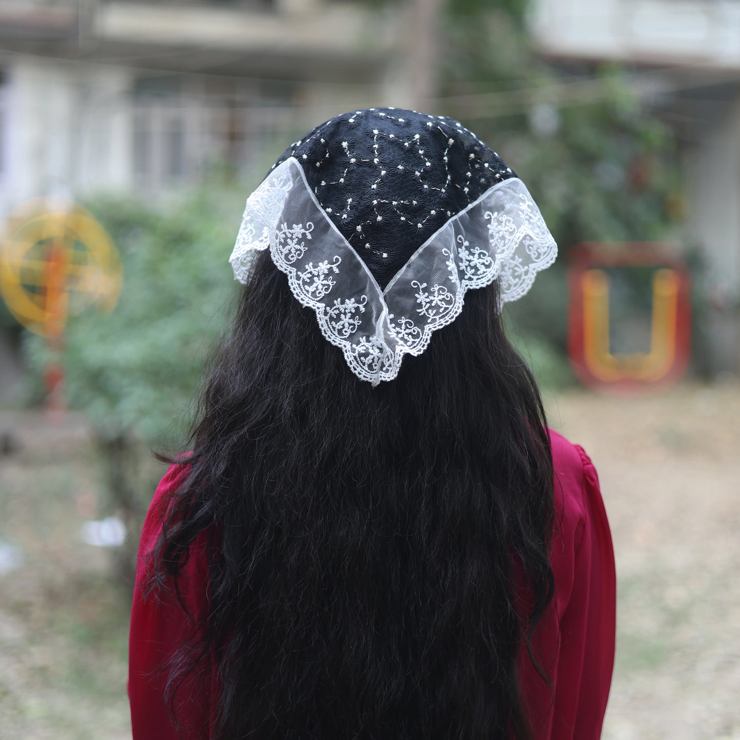 Embroidered Shimmery Lacy Bandana in black and white worn on long black hair outdoors