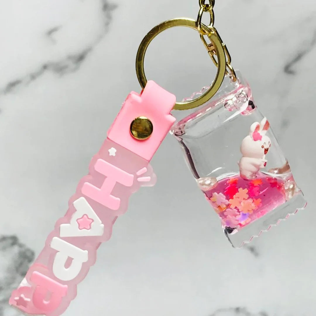 Pink Happy letter fancy key chain with clear charm containing a small bunny and pink flowers