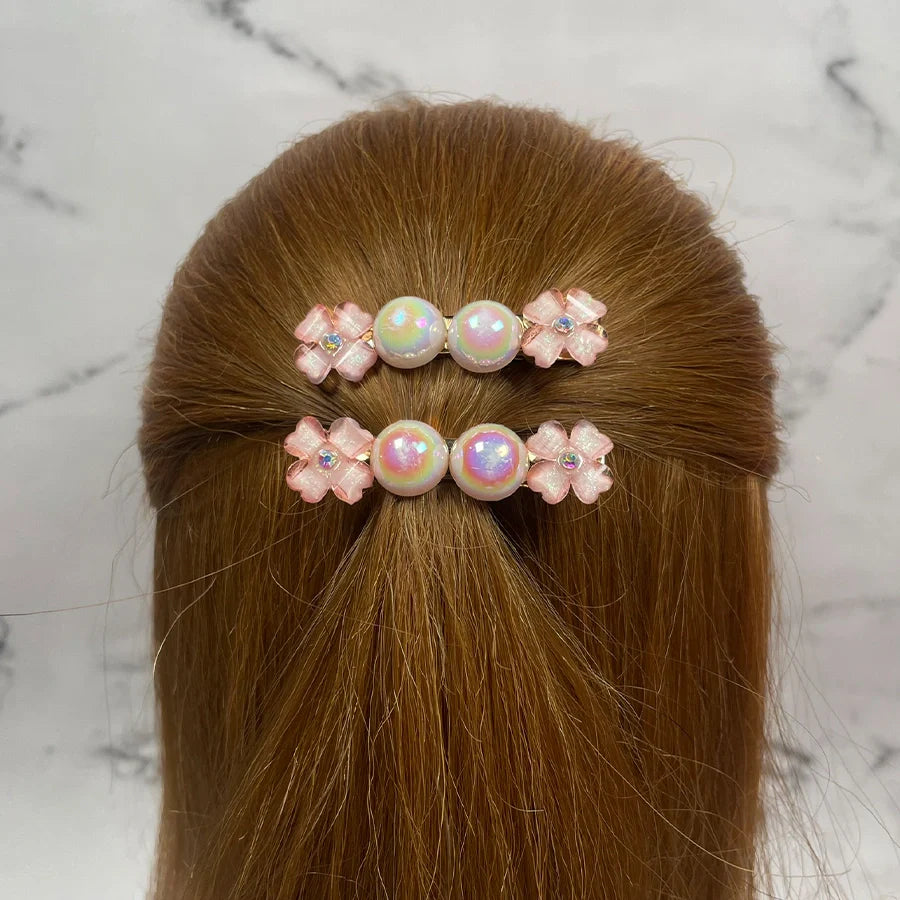 Fancy pearl flower hair pins with pink floral designs worn on light brown hair