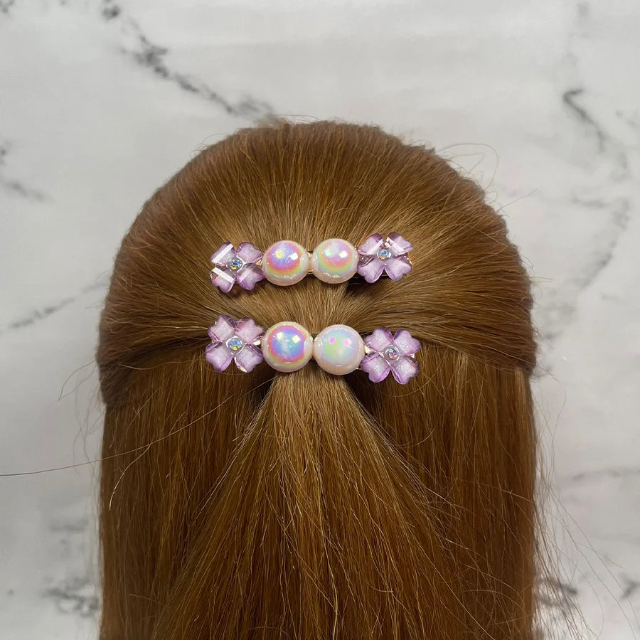 Fancy pearl flower hair pins with pink flower accents worn in brown hair half-up style