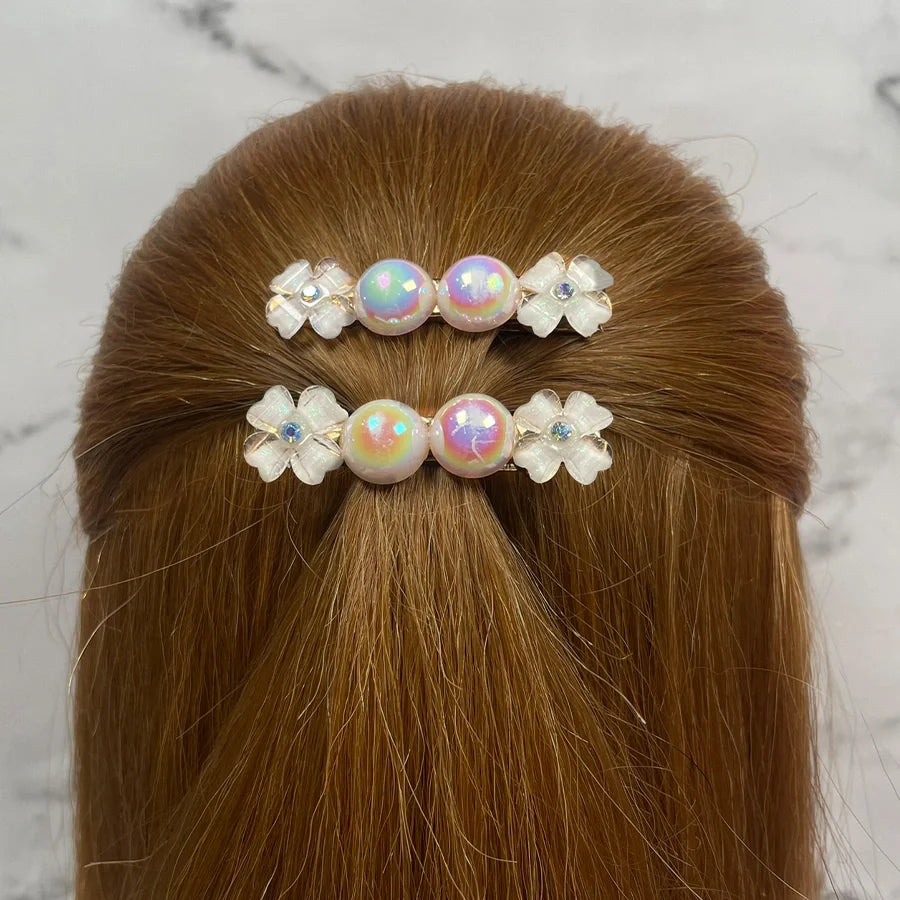 Fancy pearl flower hair pins with iridescent pearls and white floral accents on brown hair