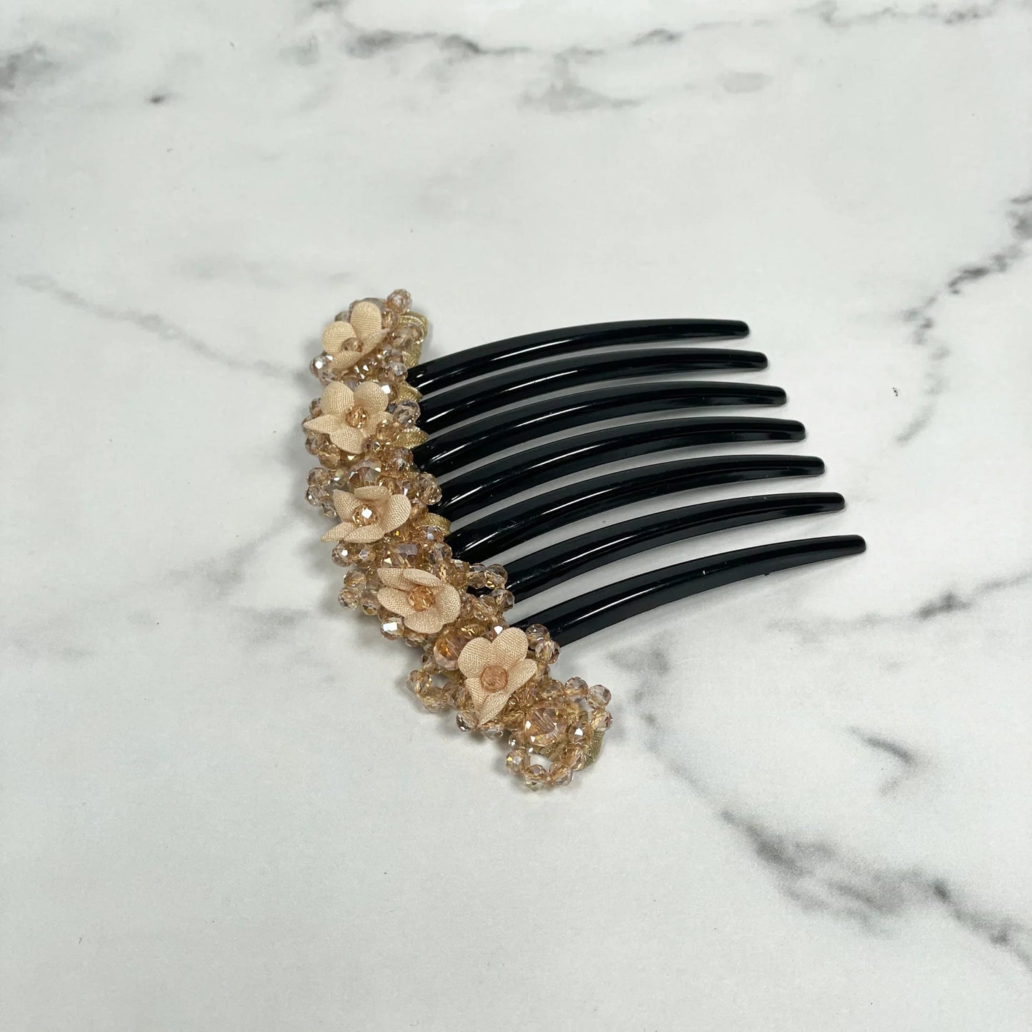 Black hair comb with beige floral beaded hair comb clips detailed decoration on marble background