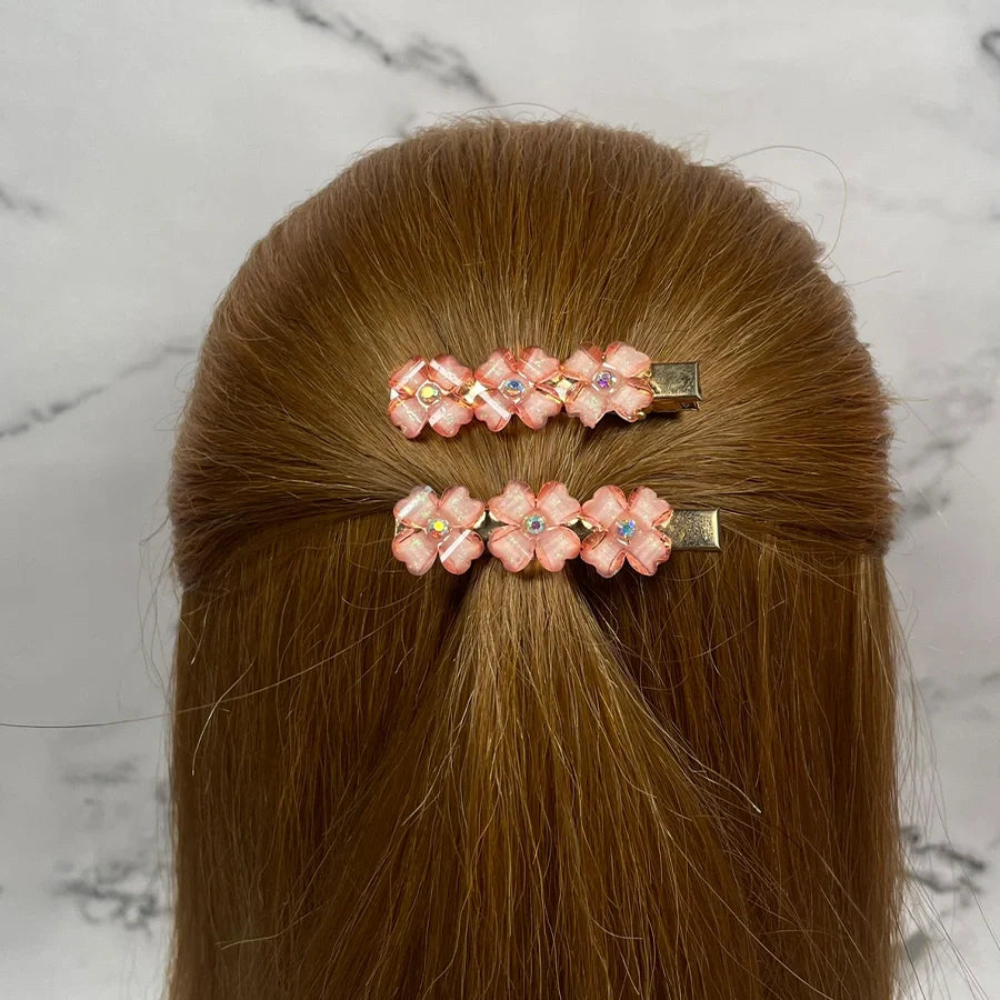 Pink floral hair pins for women with small gemstones worn on light brown hair