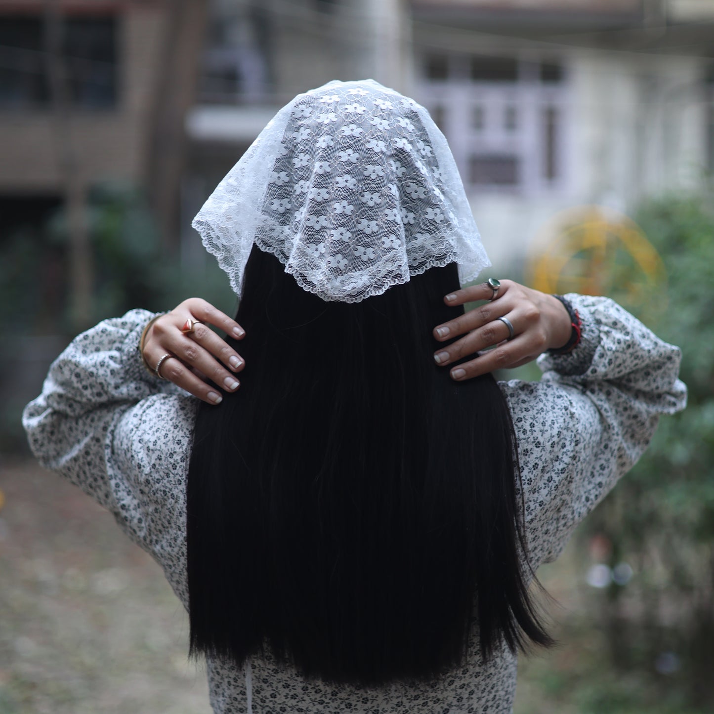 Woman wearing a flowery white lacy bandana by Bella Luxe over long black hair outdoors