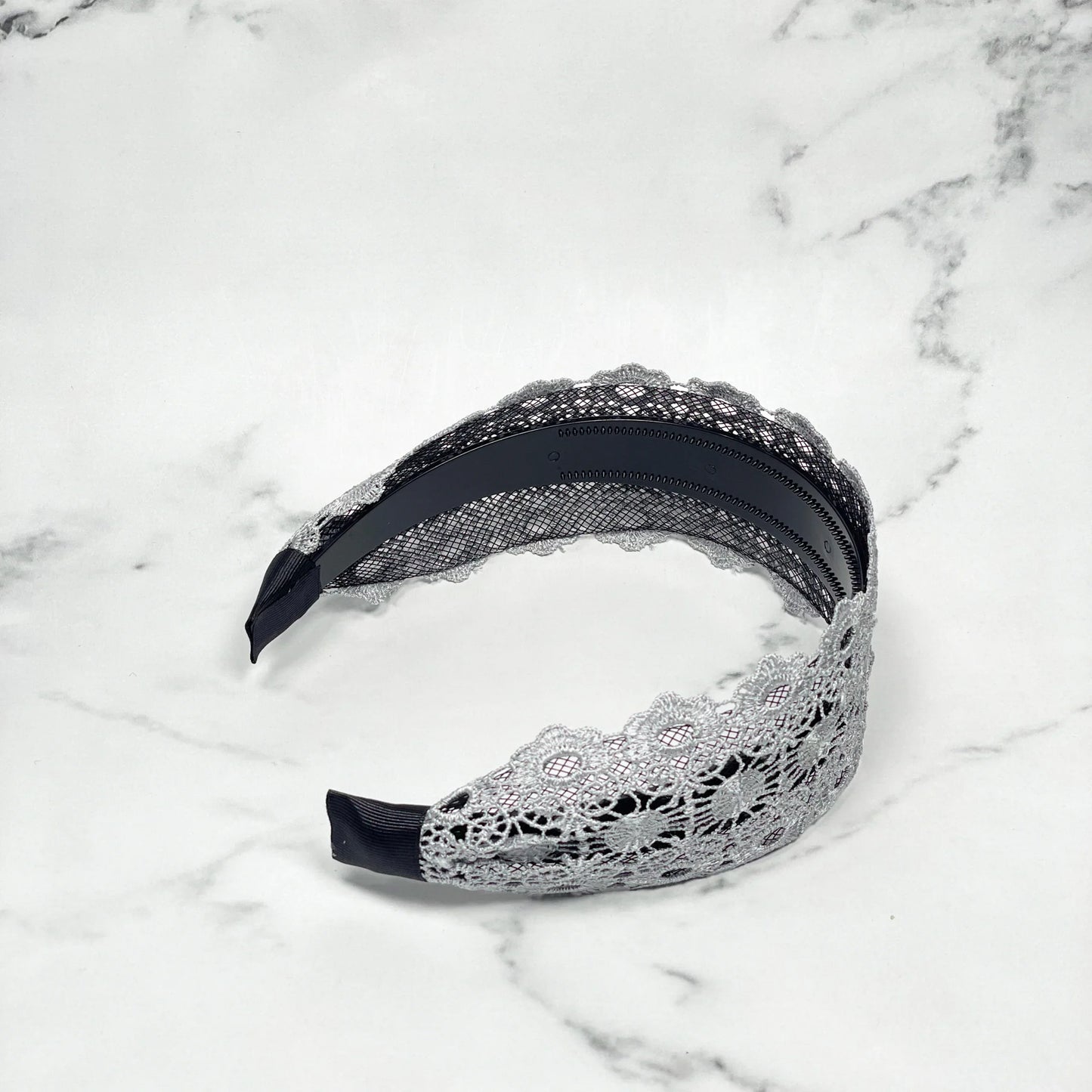 Grey lacy hairband with intricate floral lace design and black inner band for comfortable wear
