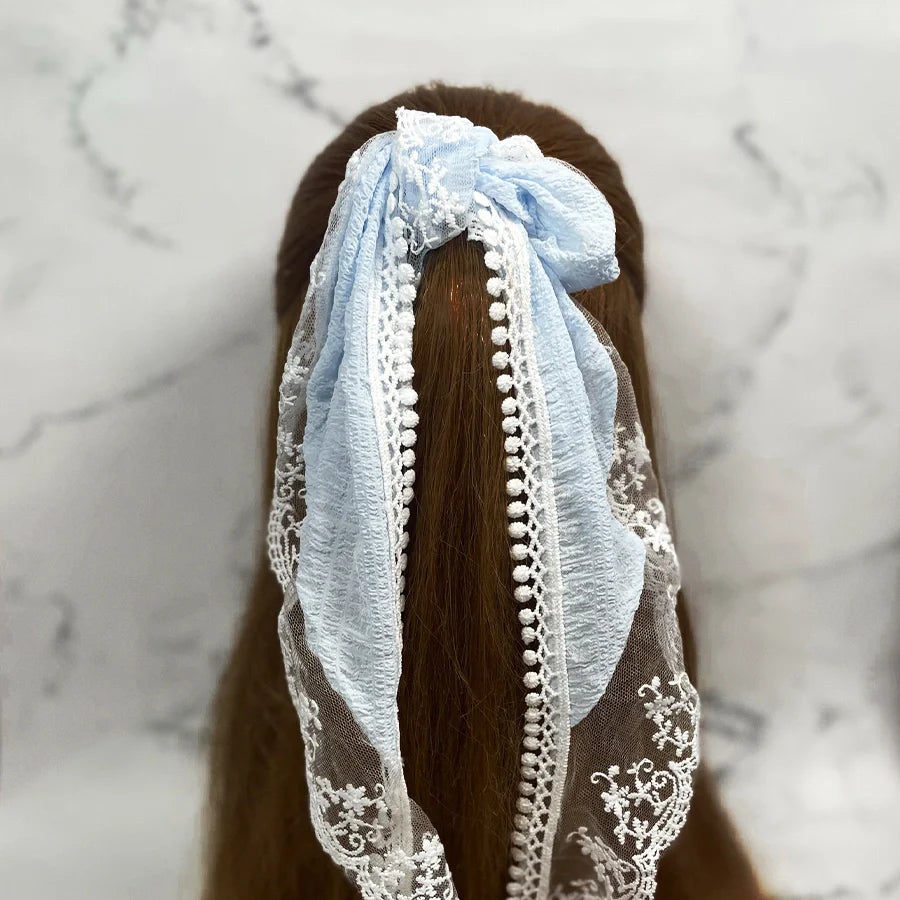 Light blue Lacy Georgette Hair Scarf with delicate white lace tied around long brown hair