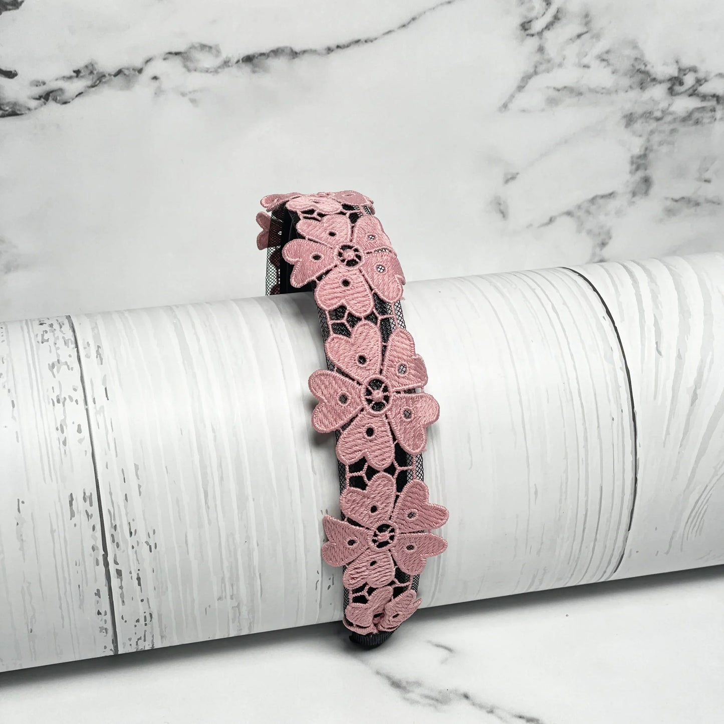 Pink Medium Broad Lacy Floral Hairbands with intricate floral lace design displayed on white wooden background