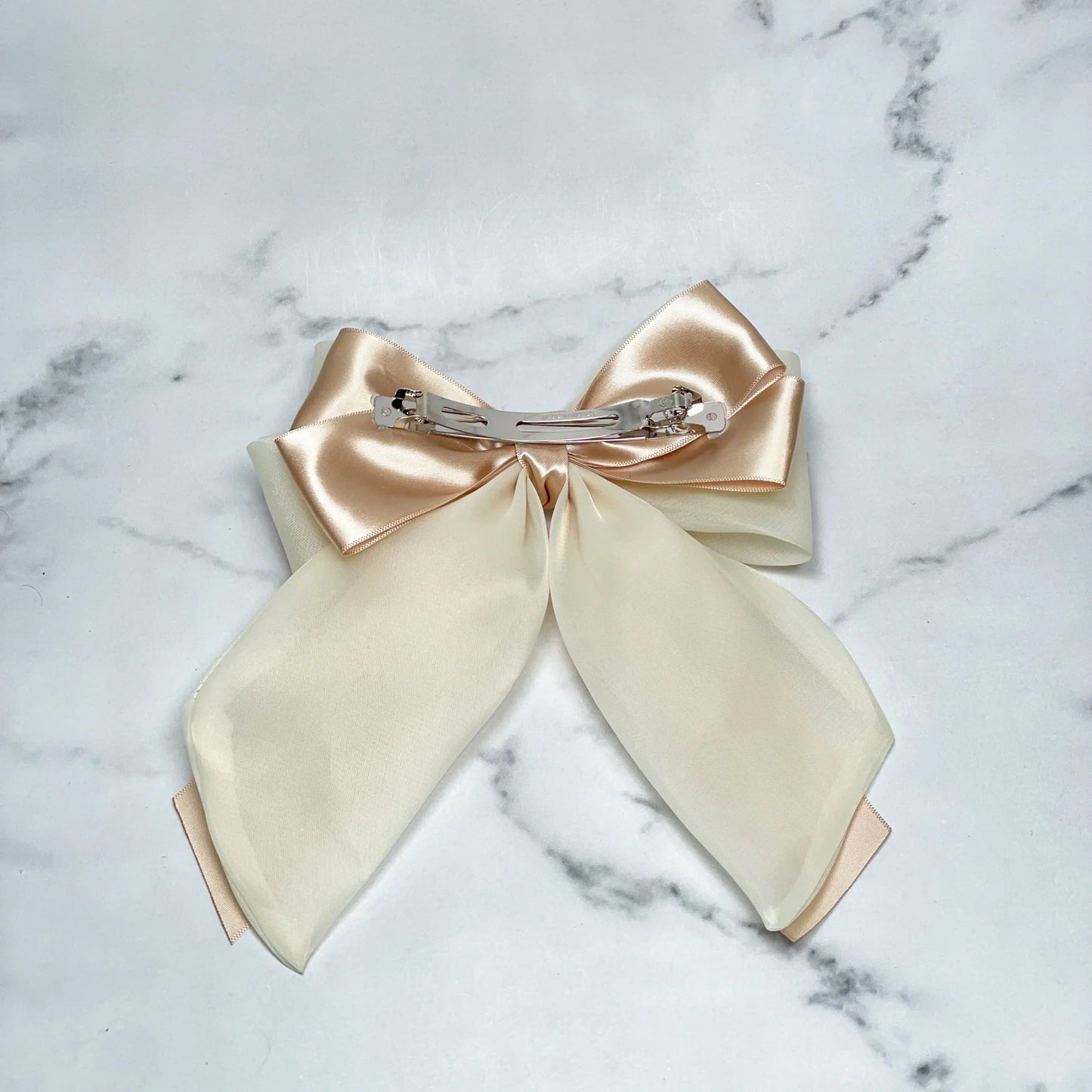 Organza and Satin Bow Clips in soft beige and cream colors with metal clip on marble background
