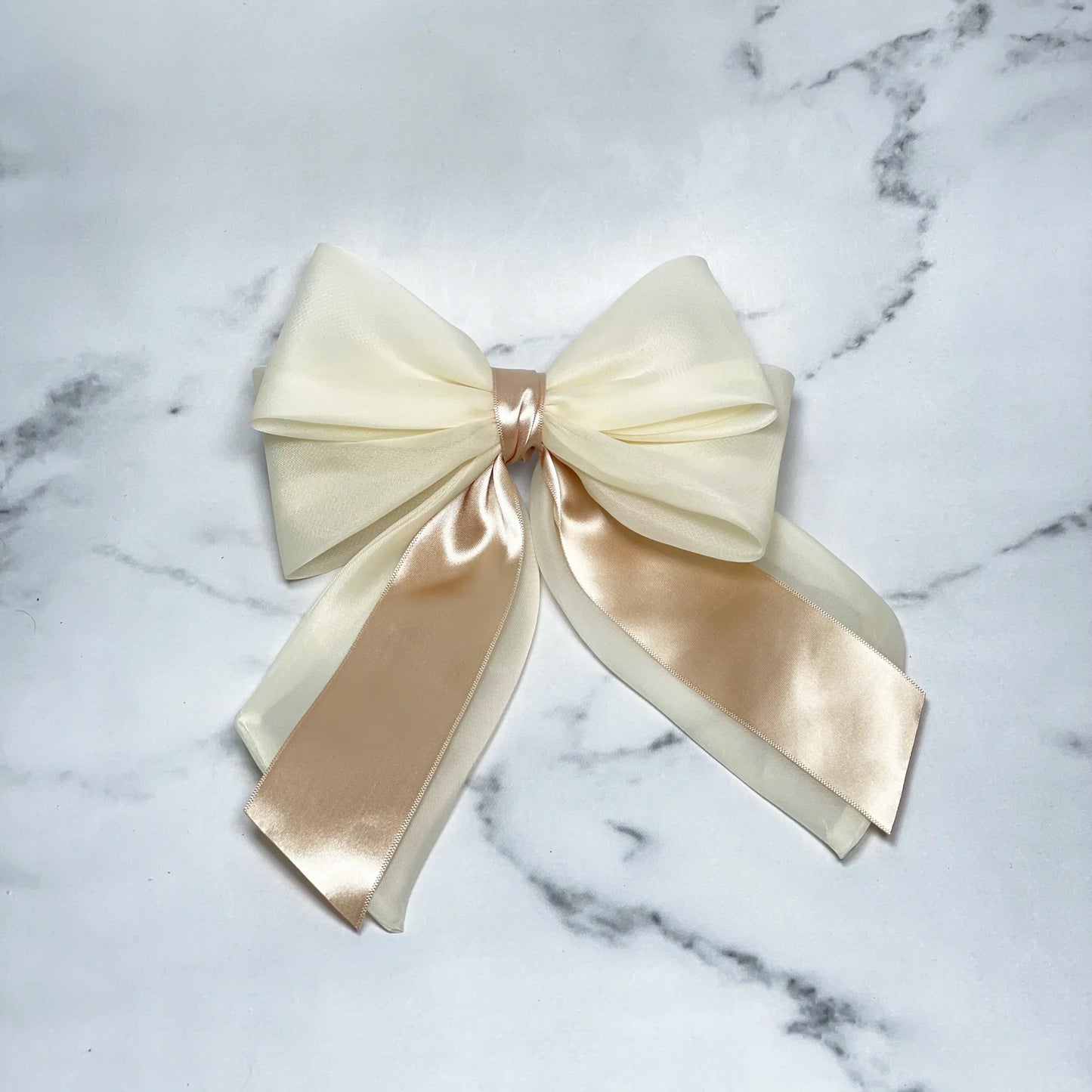 Elegant Organza and Satin Bow Clips in ivory and champagne colors on a marble background