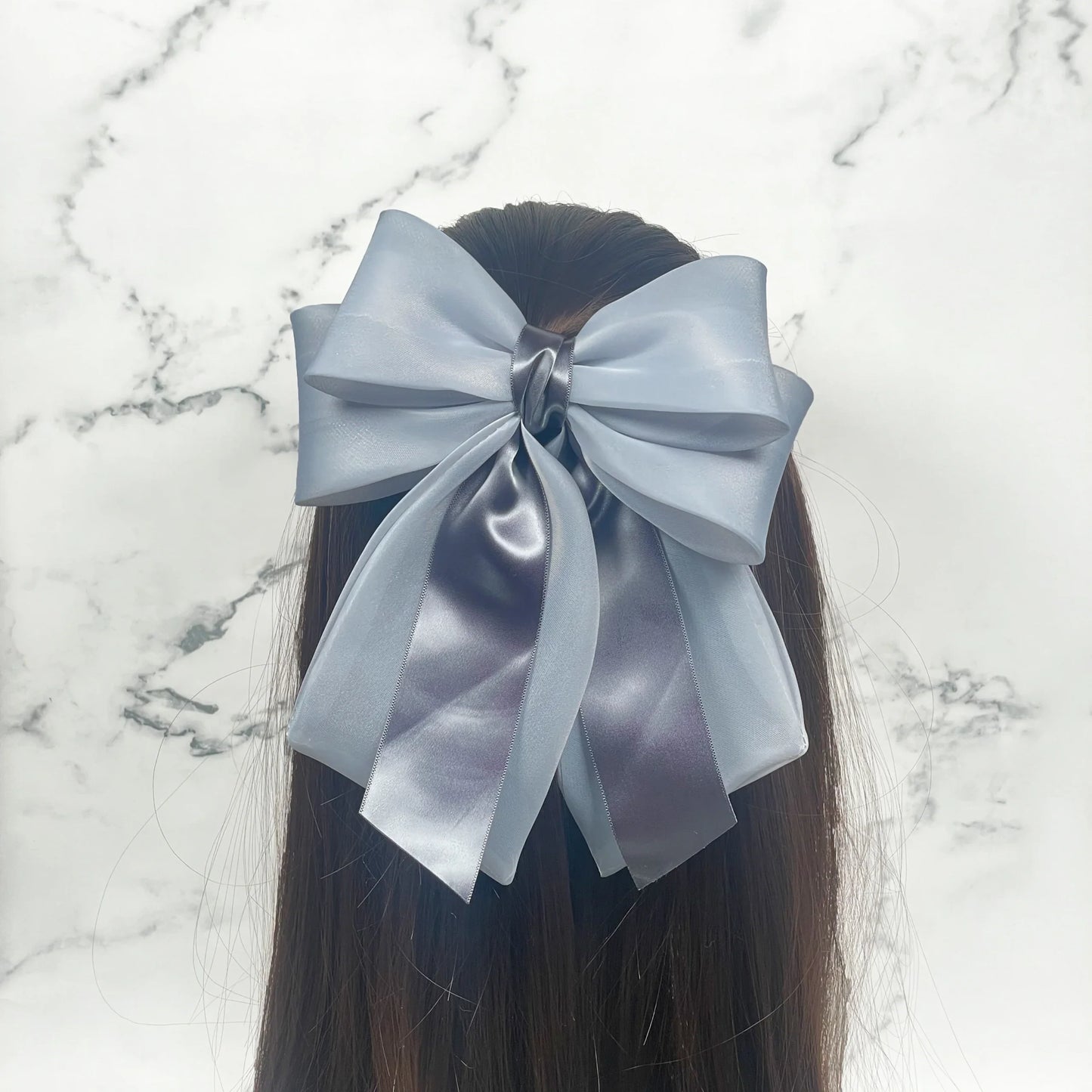 Large gray Organza and Satin Bow Clips worn on long dark hair with marble background