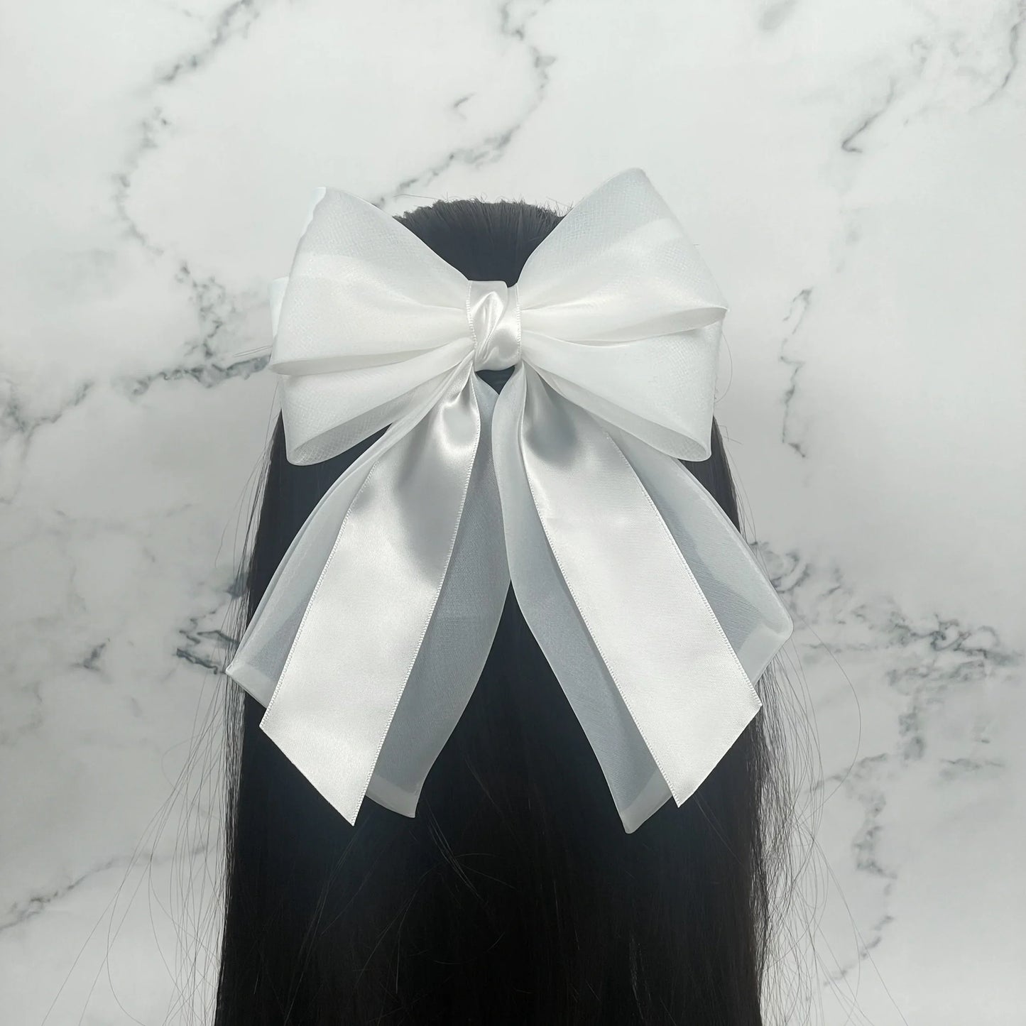 White Organza and Satin Bow Clips worn in long black hair with marble background