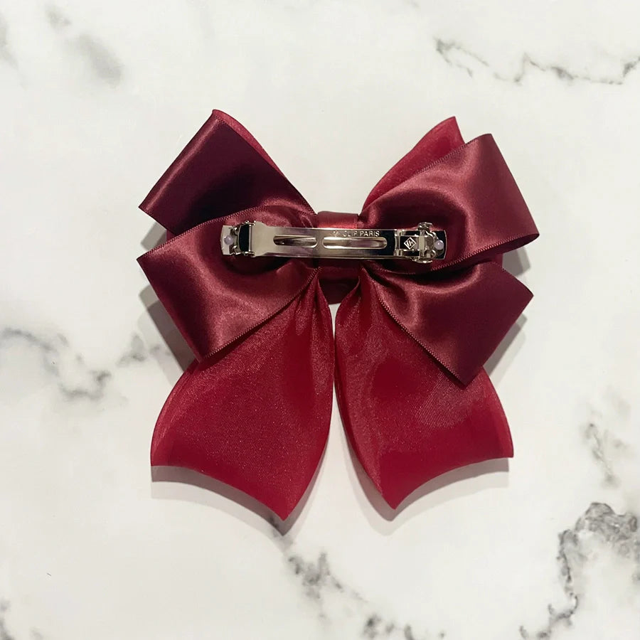 Burgundy organza satin bow hair clips with metal clasp on white marble background
