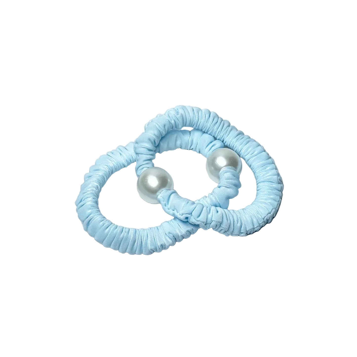 Two blue pastel hair ties with pearl detail on a white marble surface