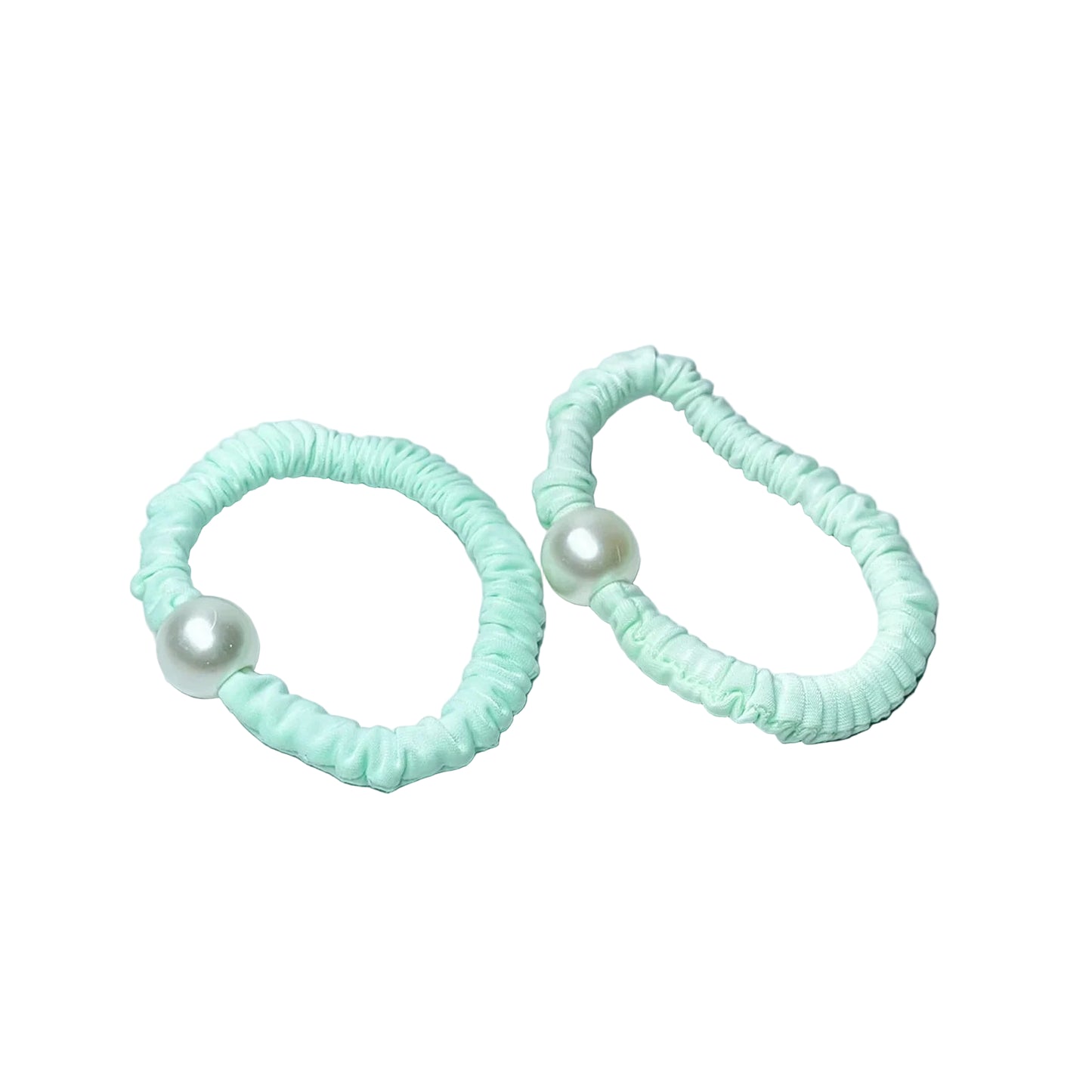 Pastel hair ties with pearl decoration in light mint green on a marble surface