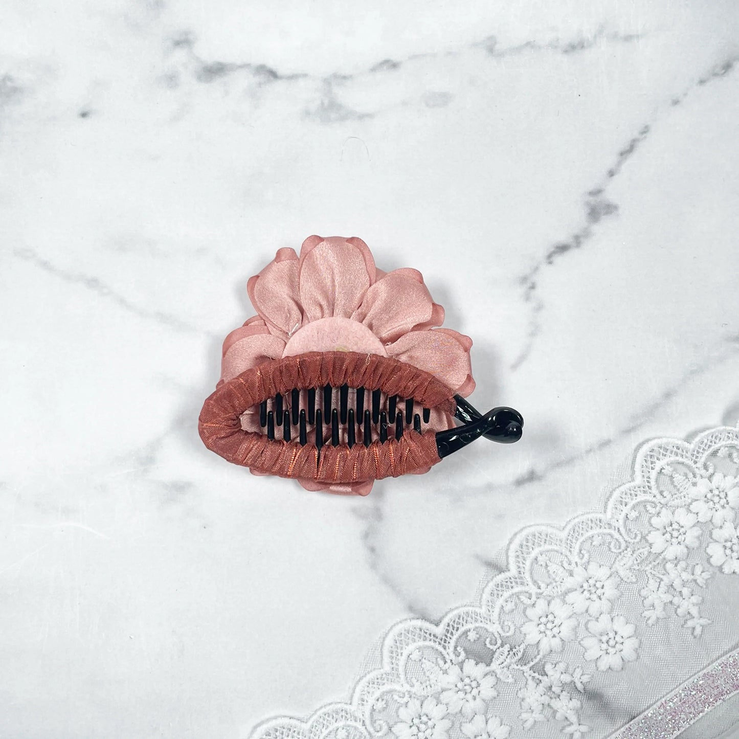 Bella Luxe peach crystal banana clips with flower design on marble background