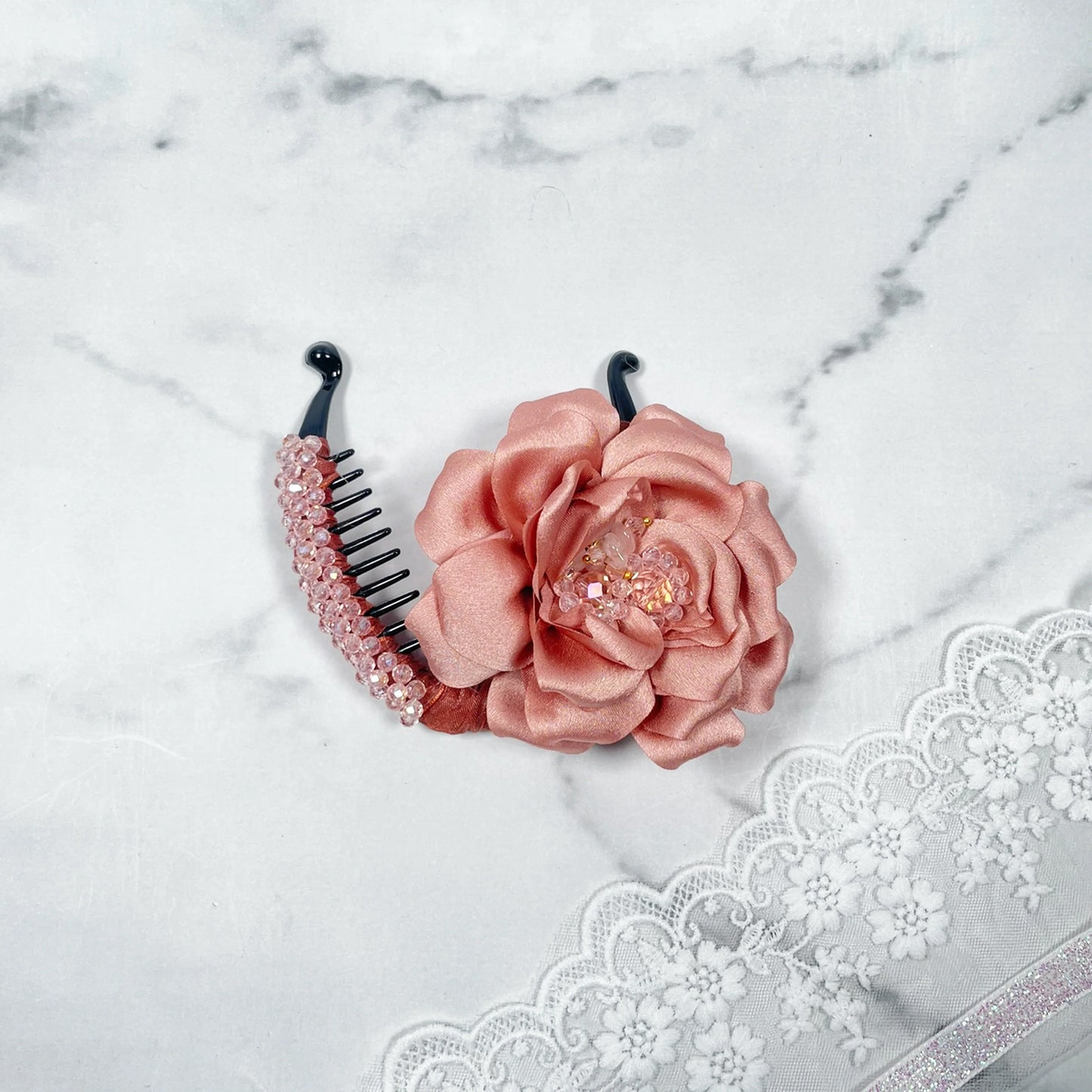 Bella Luxe peach crystal banana clips featuring a peach fabric flower and crystal accents on black clip