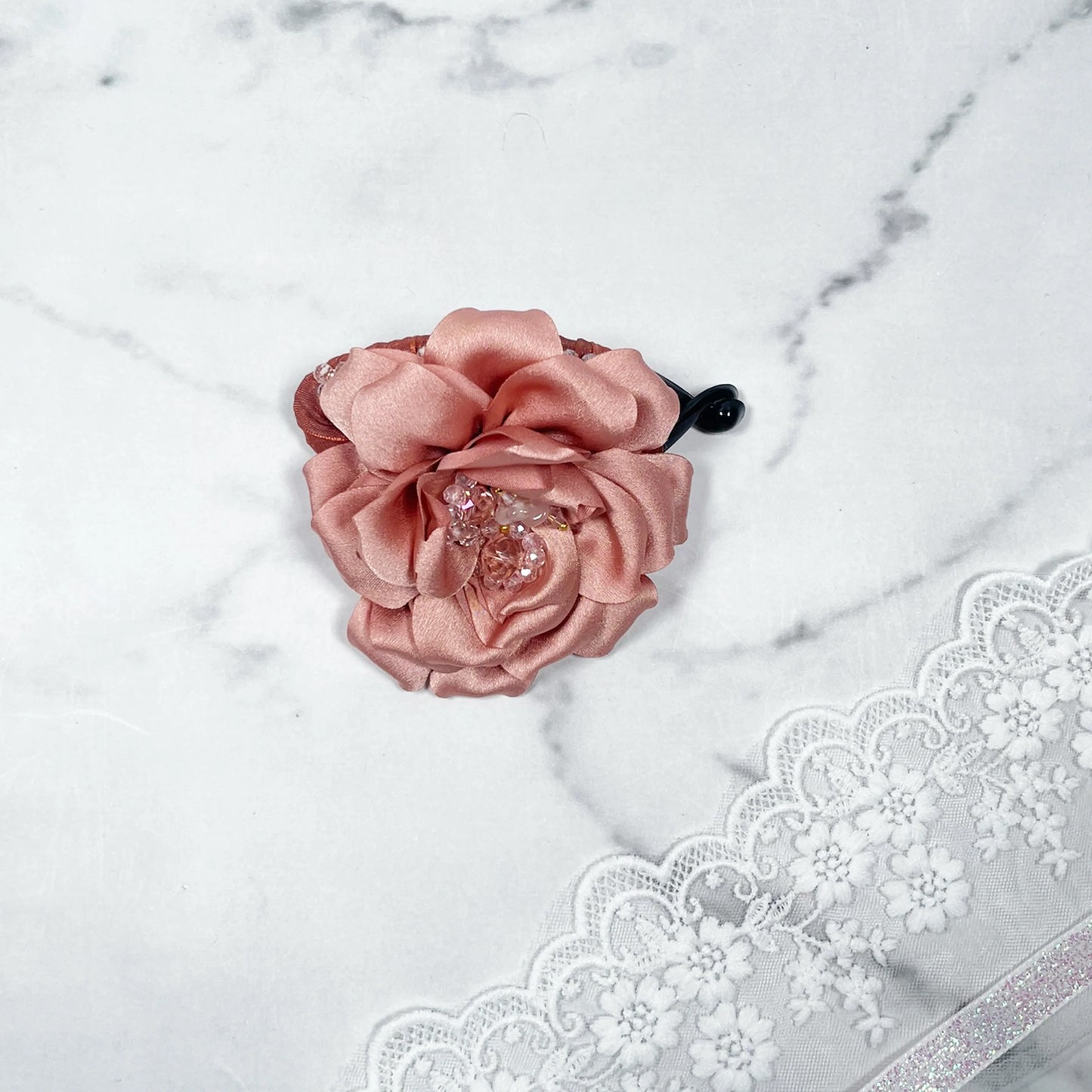 Bella Luxe peach crystal banana clips with fabric flower and crystal accents on marble background