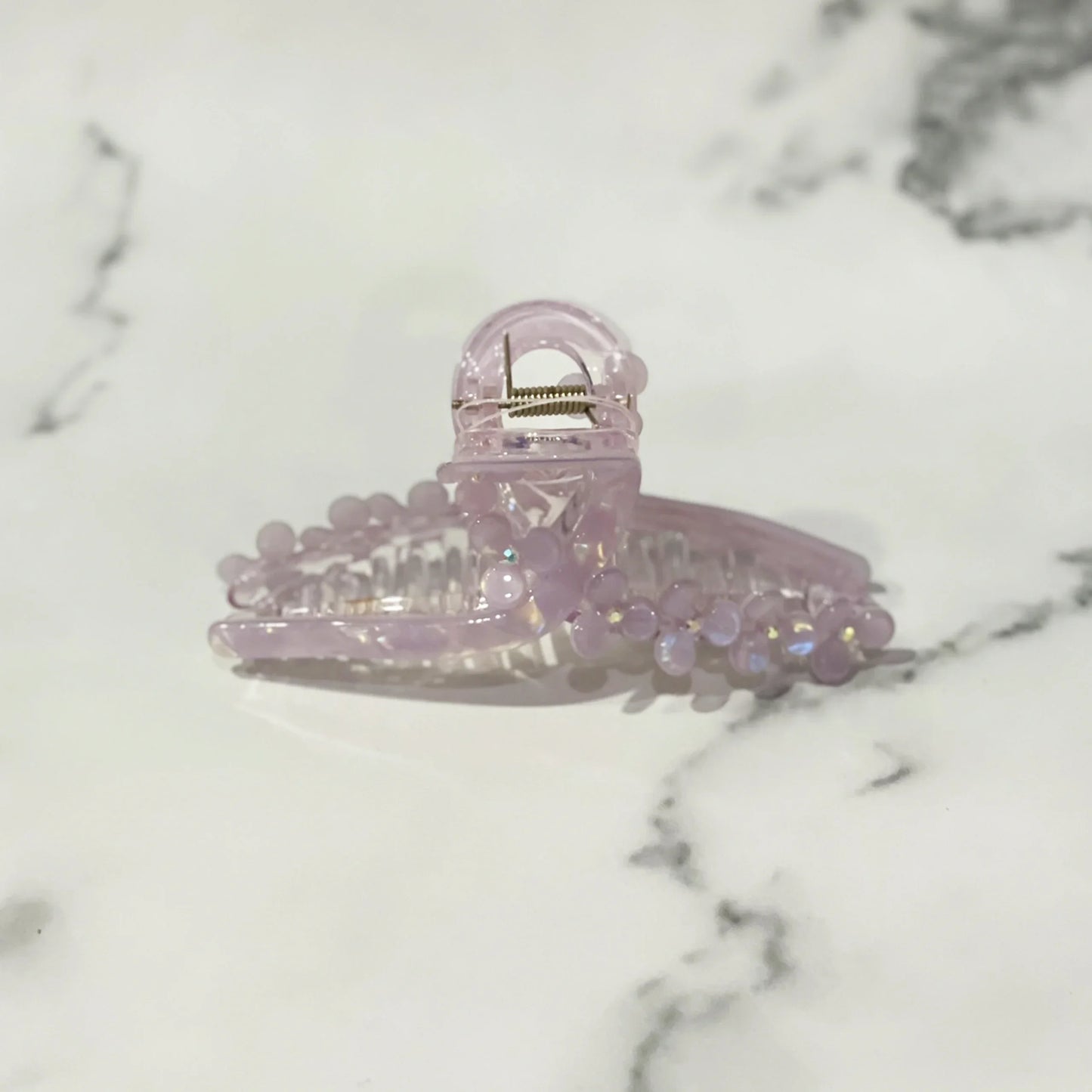 Light purple pearl floral hair clutches with decorative beads on a marble background