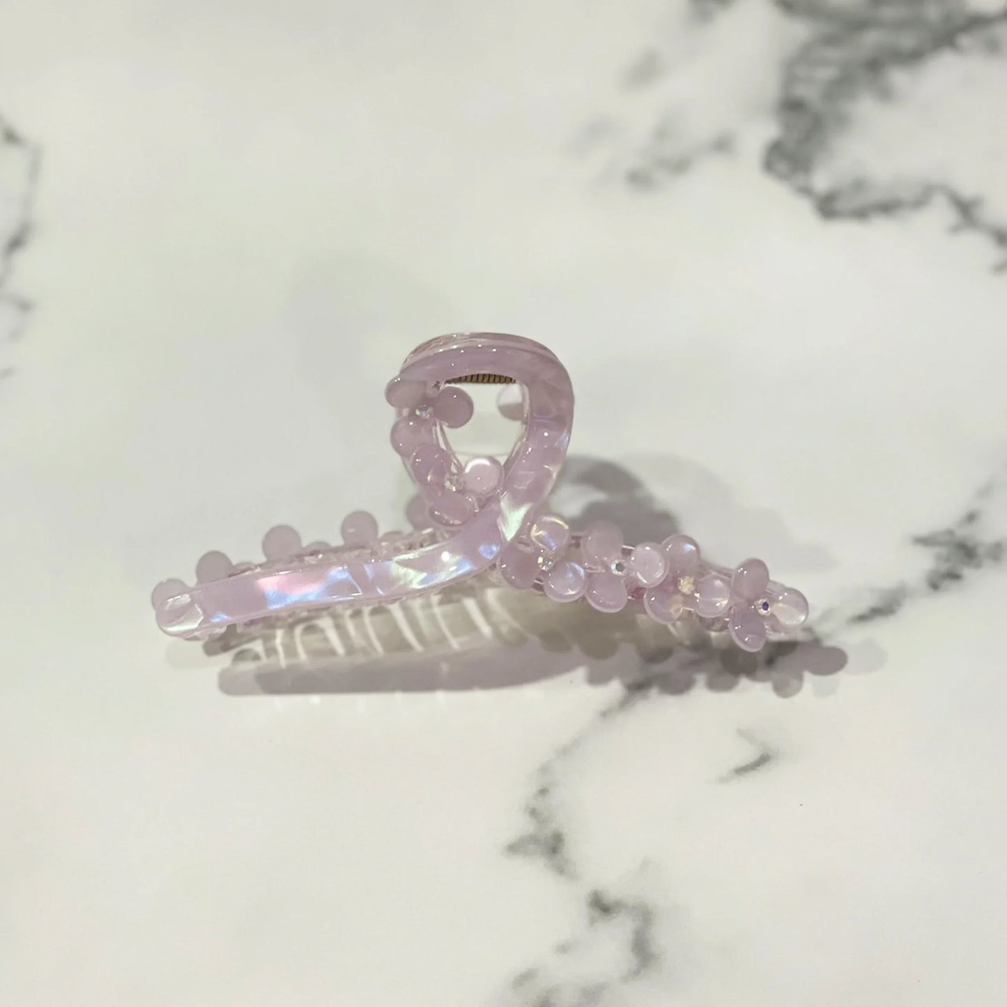 Light pink pearl floral hair clutches with a translucent finish on marble background