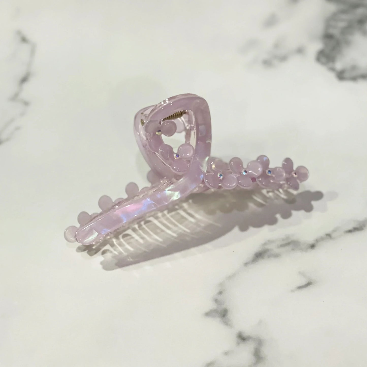 Light purple pearl floral hair clutches with rounded bead details on a marble surface