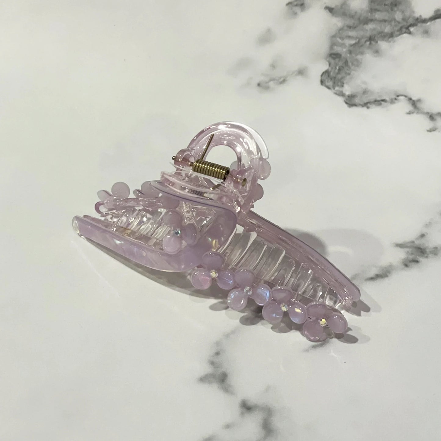 Light purple pearl floral hair clutches with translucent design on marble background