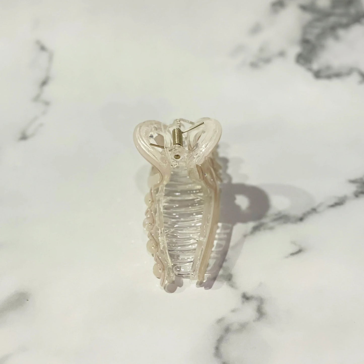 Clear pearl floral hair clutches with delicate pearl accents on marbled surface