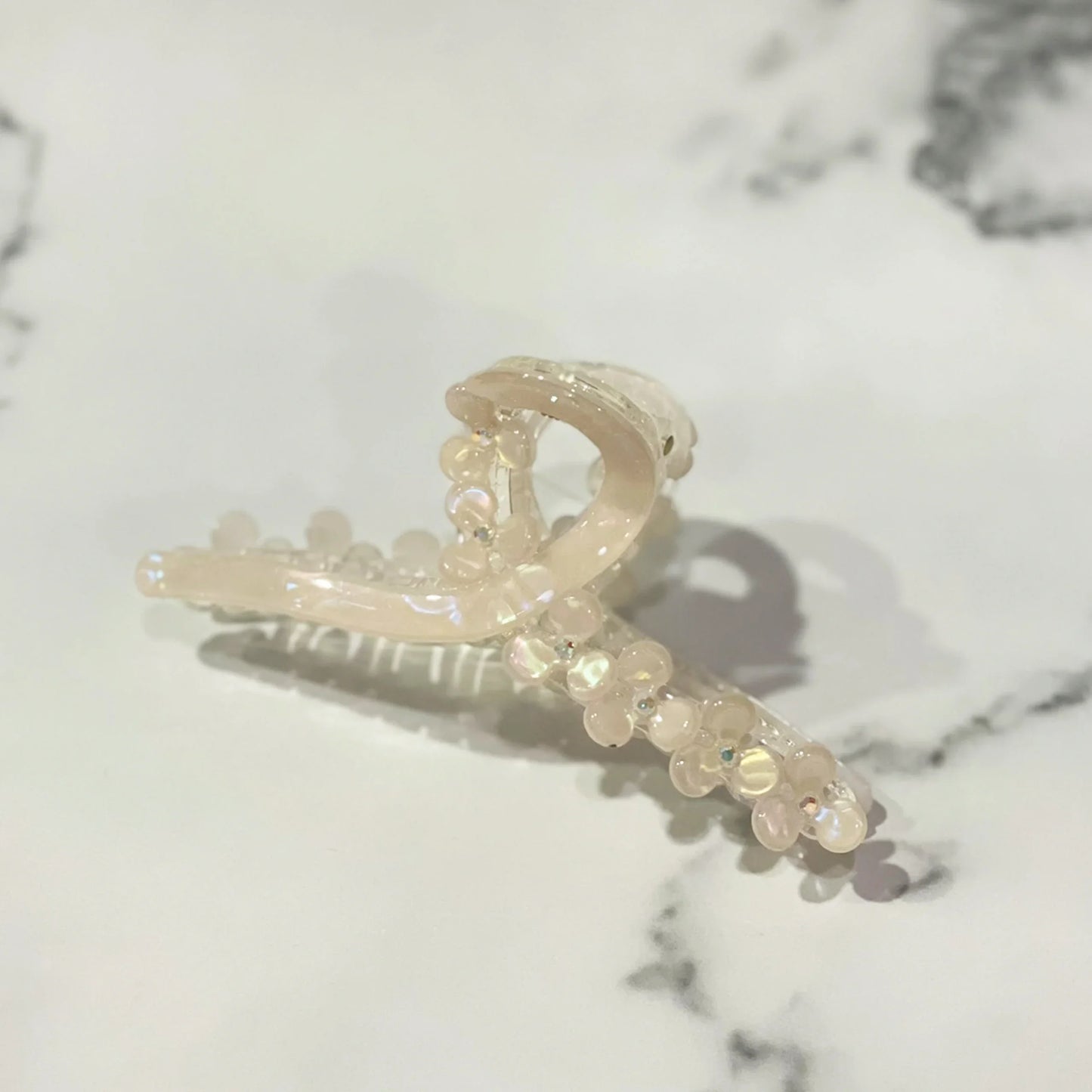 Elegant pearl floral hair clutches with translucent beads on a marble surface