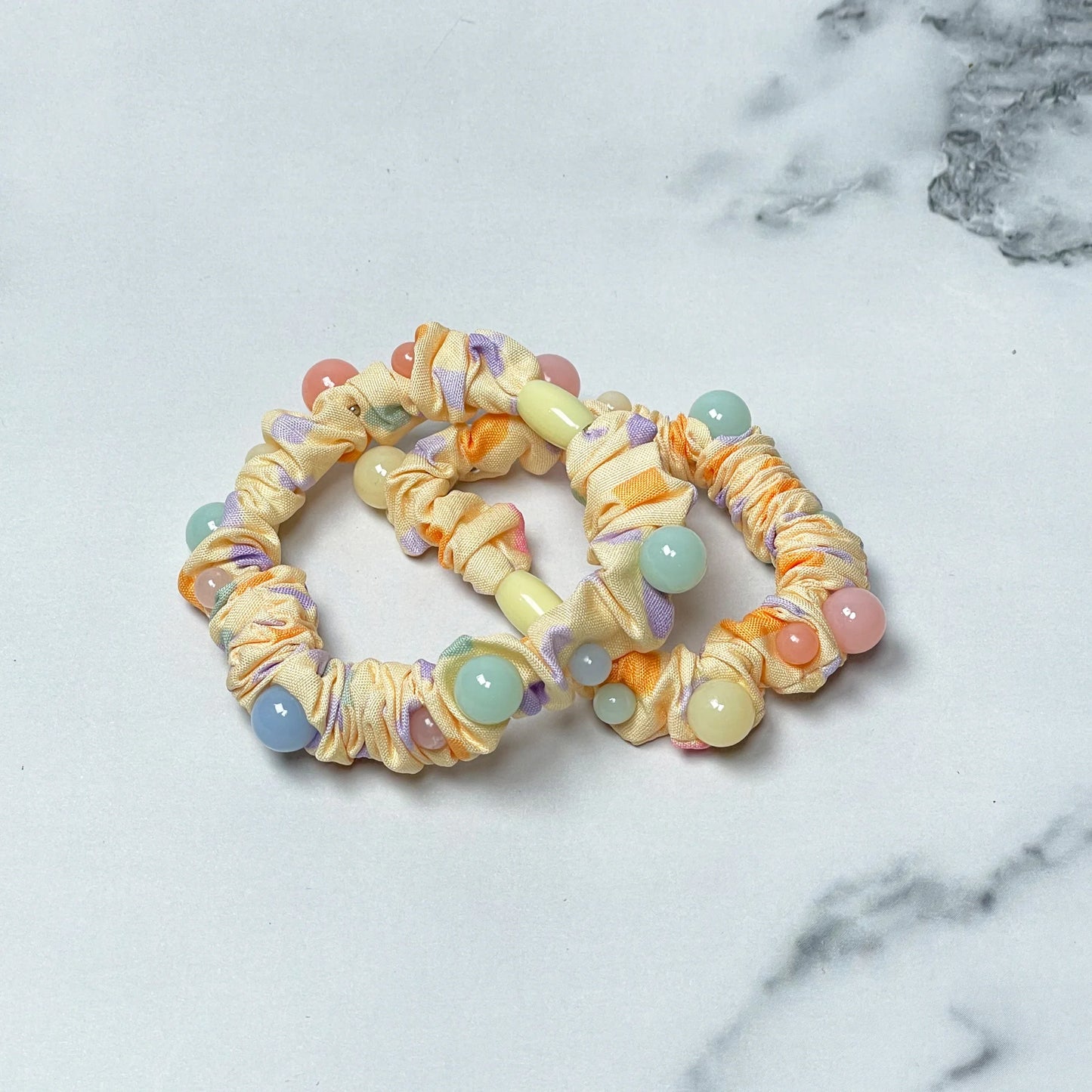 Colorful printed hair ties with beads on light fabric scrunchies for stylish hair accessories