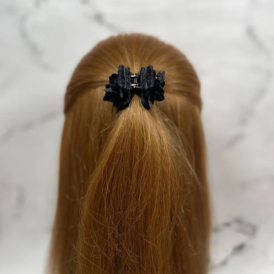 Black studded hair clutches securing half-up hairstyle on long red hair