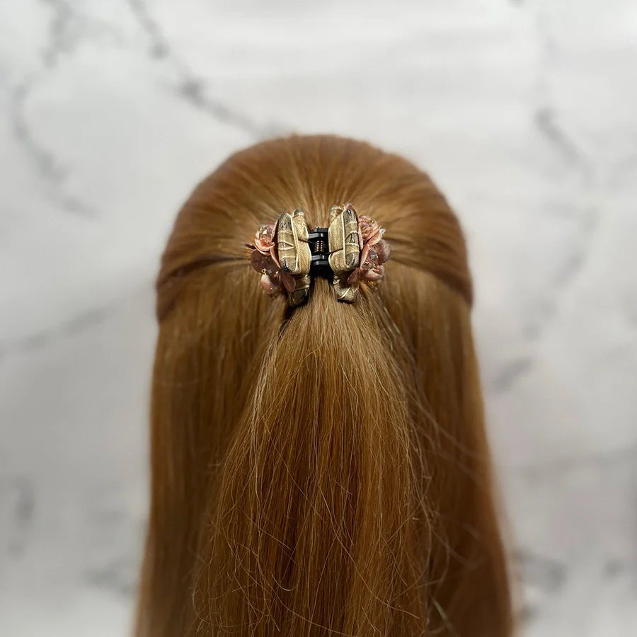 Brown hair styled with studded hair clutches holding half-up hairstyle securely in place