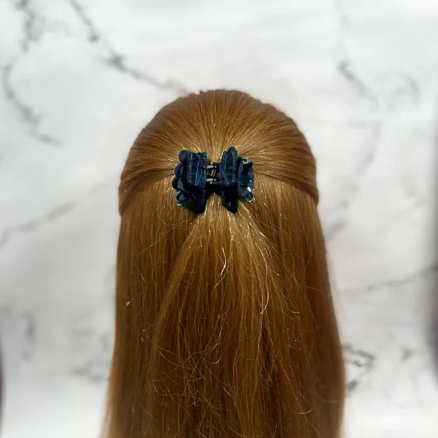 Black studded hair clutches securing half-up hairstyle on long light brown hair