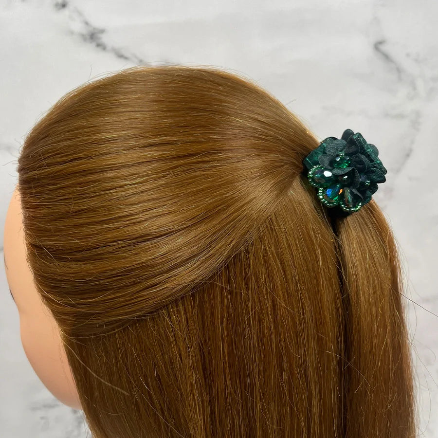 Green studded hair clutches securing half-up hairstyle on light brown hair
