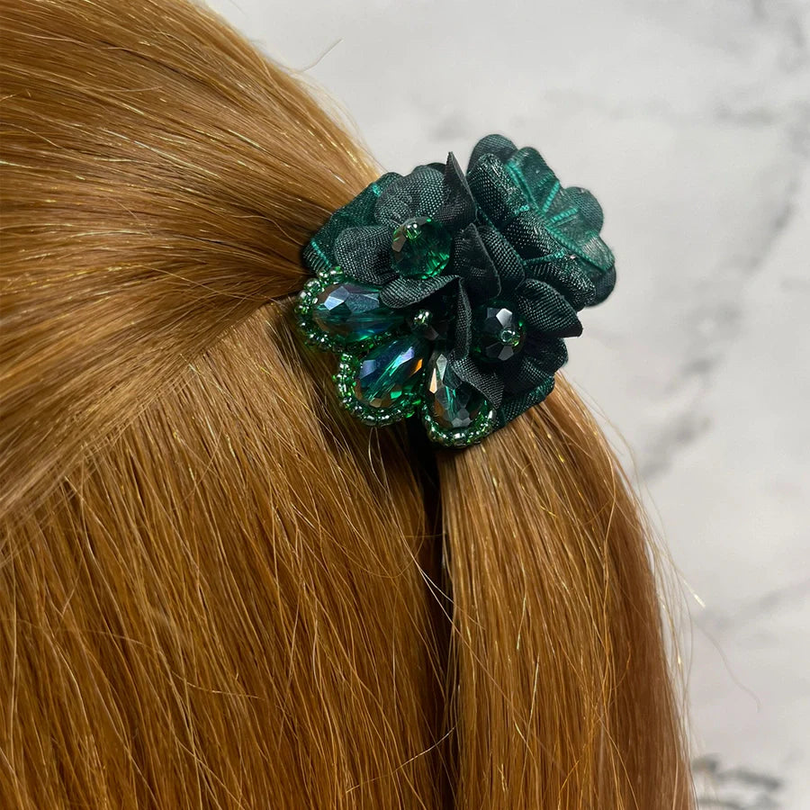 Green floral studded hair clutches securing light brown hair with decorative gemstones