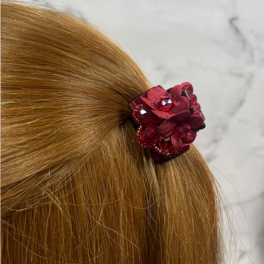 Red floral studded hair clutches securing light brown hair with decorative gemstones