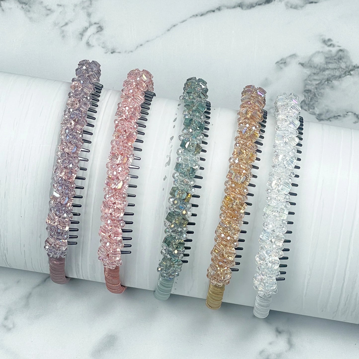 Set of five colorful studded headbands with crystal-like embellishments displayed on white surface