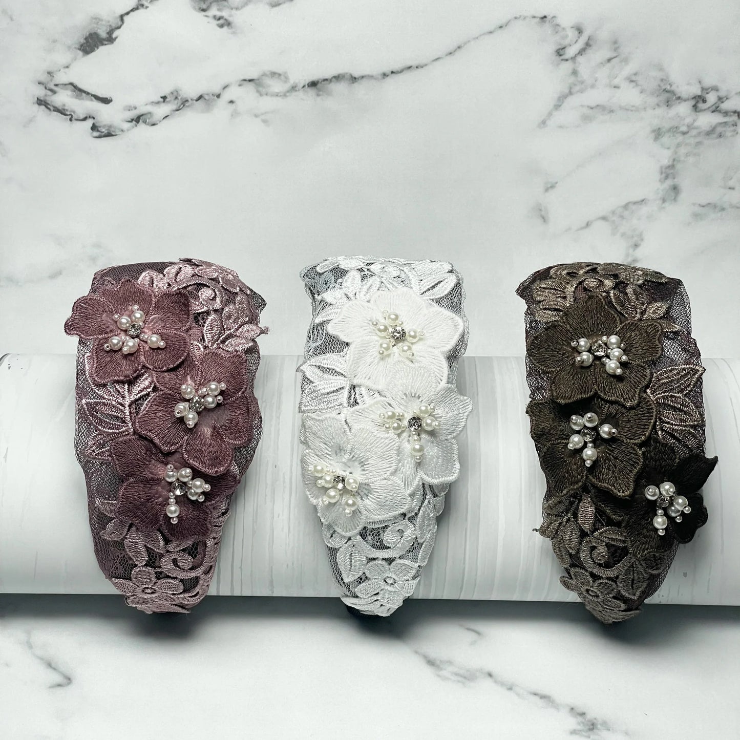 Three flower broad hairbands in pink, white, and brown with lace and pearl accents