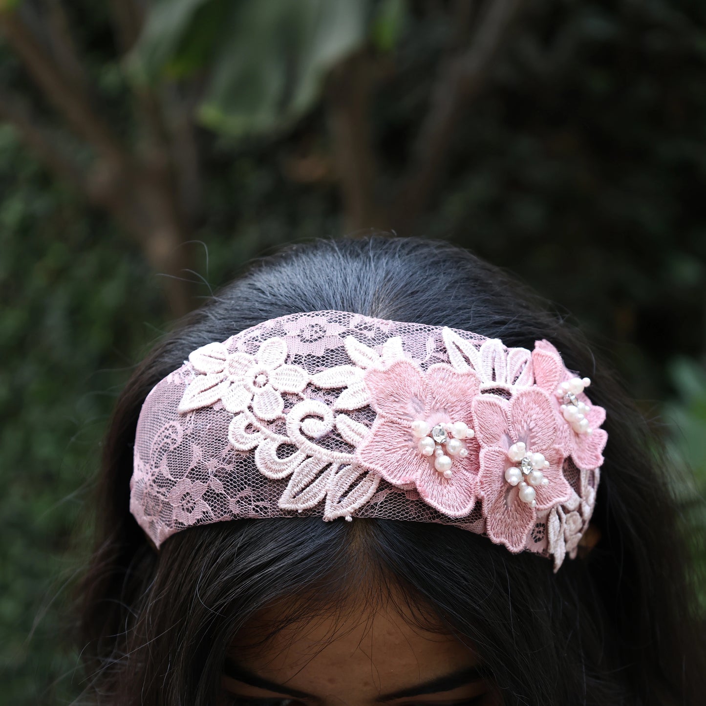 Pink lace three flower broad hairbands with pearl accents worn on dark hair