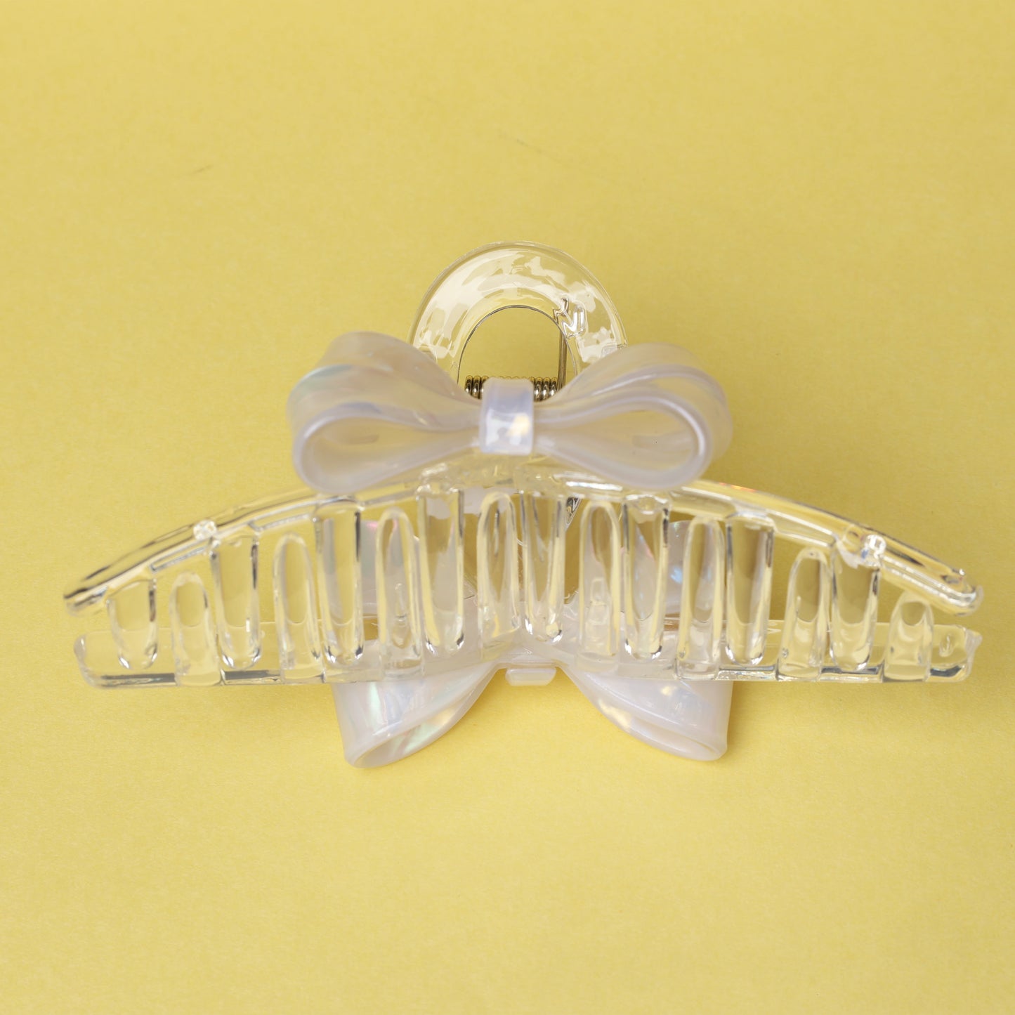 Clear plastic bow hair clutches with a decorative bow detail on a yellow background